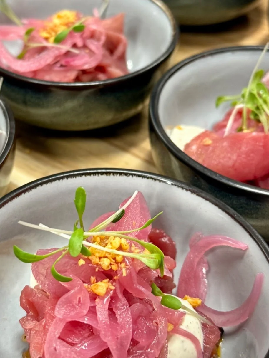 Borden met gerookte zalm, roze uitjes, kappertjes, en verse microgroenten.