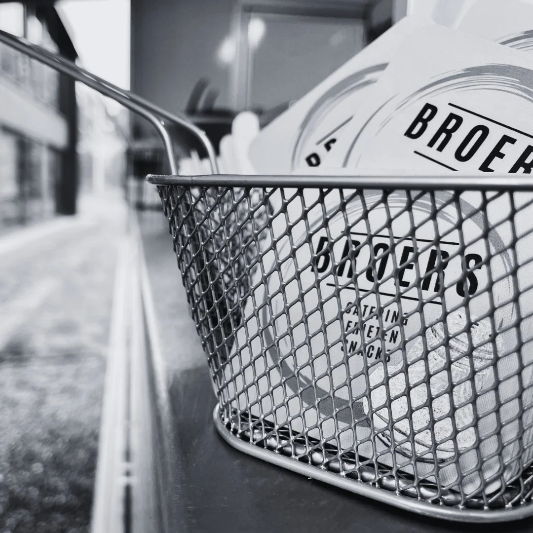 Een winkelmandje met balletjes met tekst erop, geplaatst op een plank.