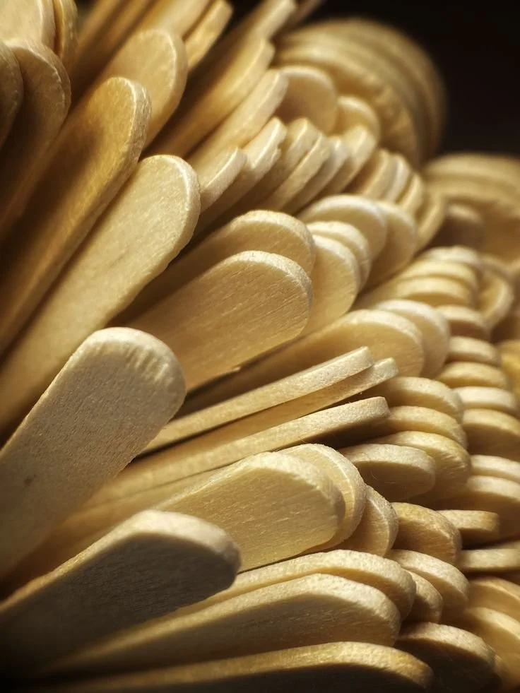 Close-up of a large pile of wooden popsicle sticks.