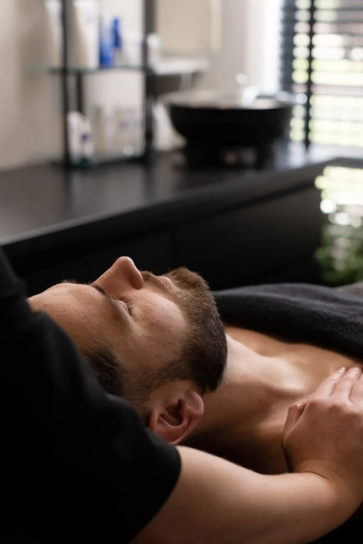 A person receiving a massage in a wellness or spa setting with blurred background.