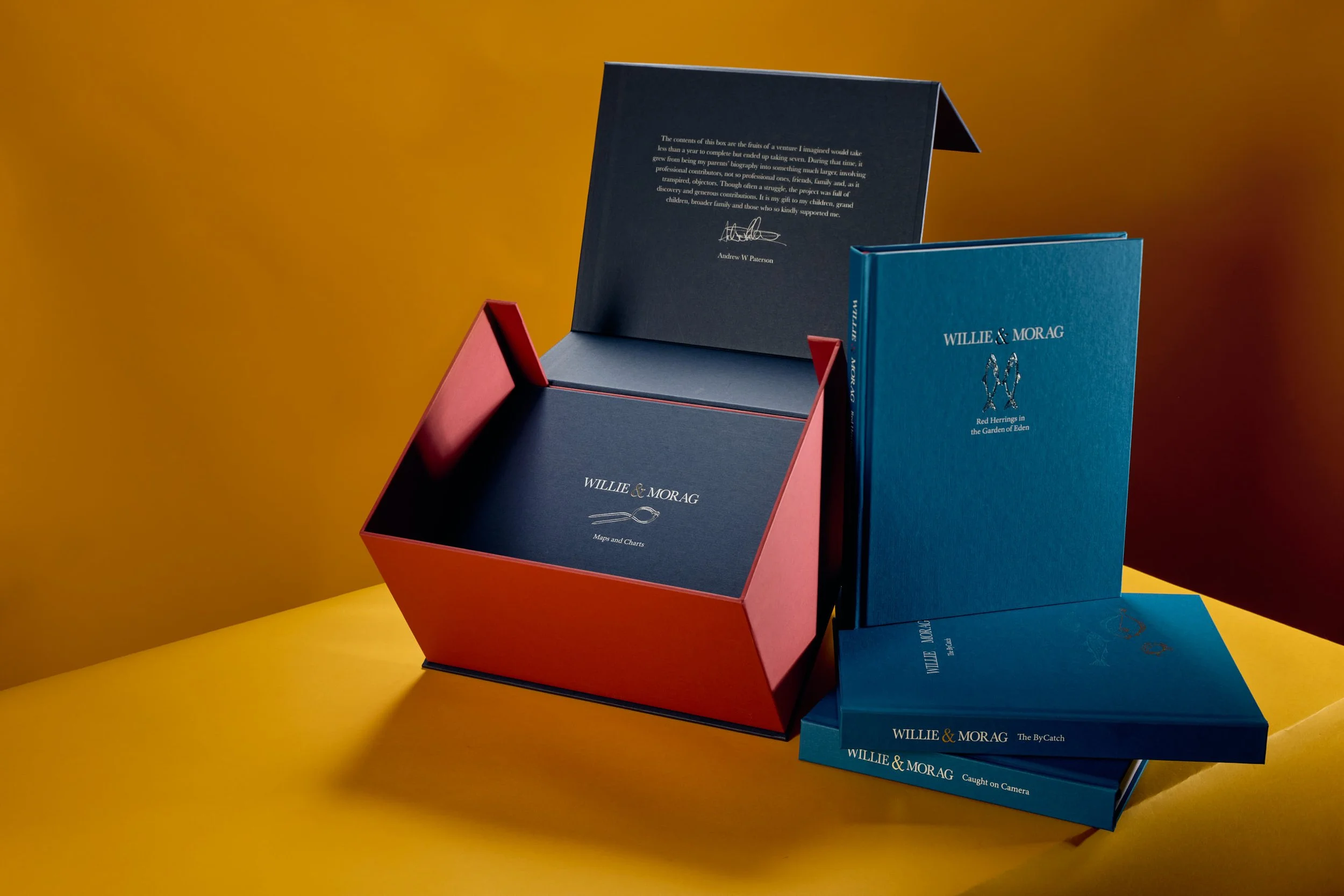 Colorful boxes and books arranged on a yellow background, with one open box displaying a handwritten note inside.
