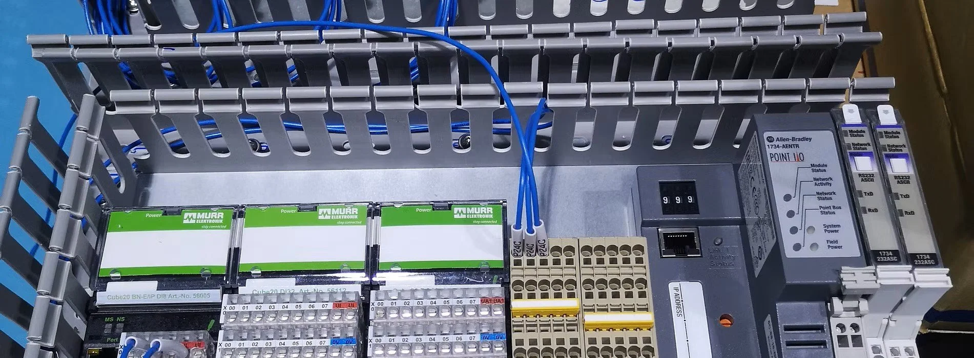 Electrical control panel with wiring, circuit breakers, and communication modules.