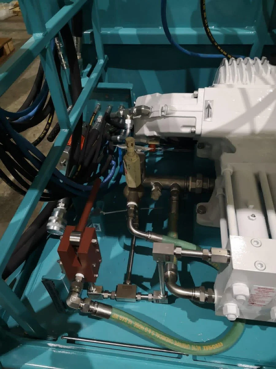 Close-up of hydraulic and pneumatic machinery with metal pipes, hoses, and valves, part of industrial equipment.