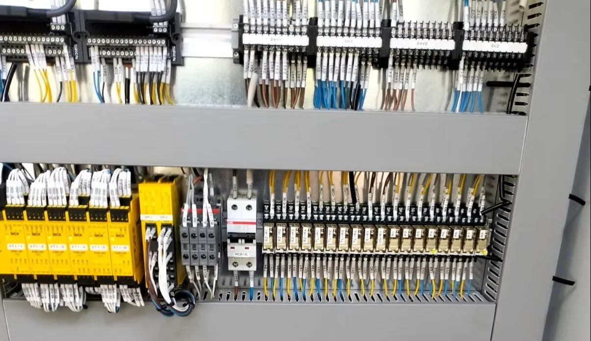 Electrical control panel with various wires, relays, and circuit breakers.
