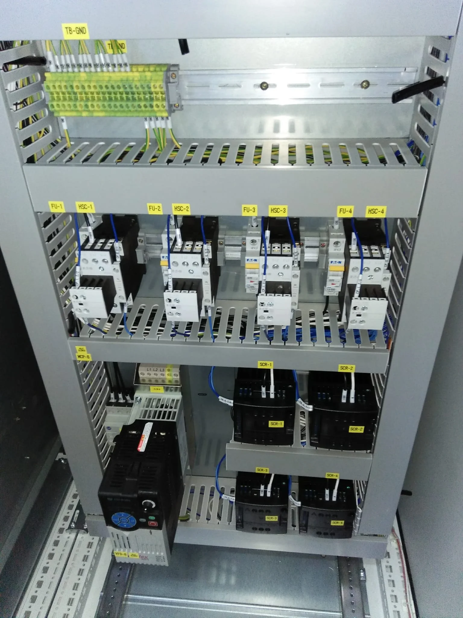 Electrical control panel with relays, circuit breakers, wiring, and labeled components.