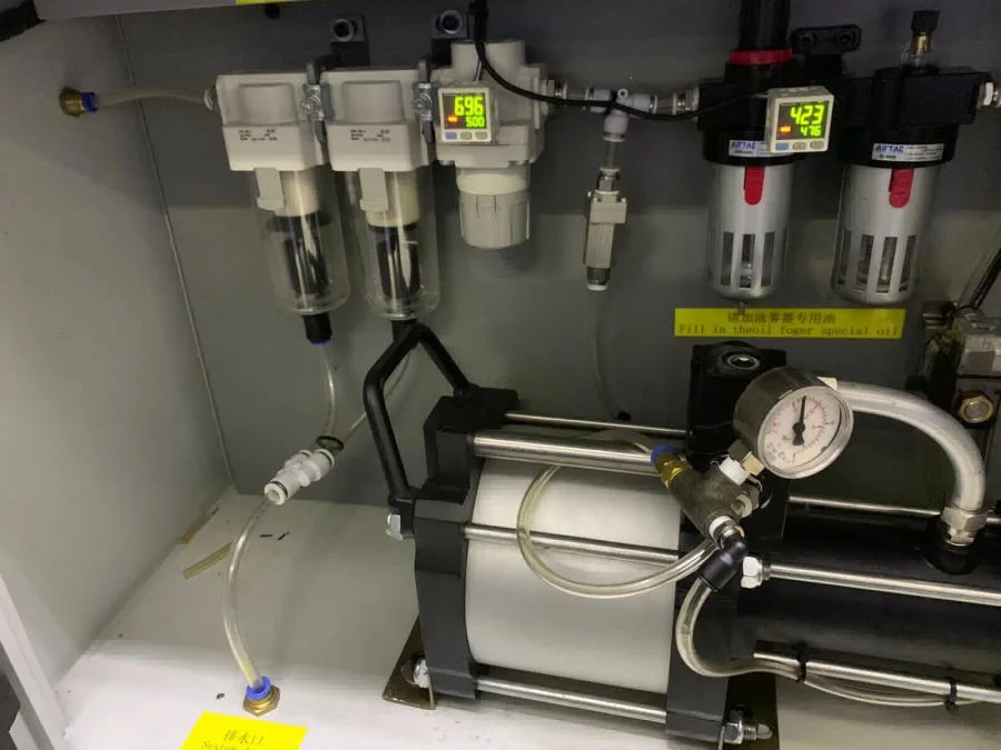 Close-up of scientific or industrial equipment with gauges, filters, and tubing, including digital display screens showing numerical readings.
