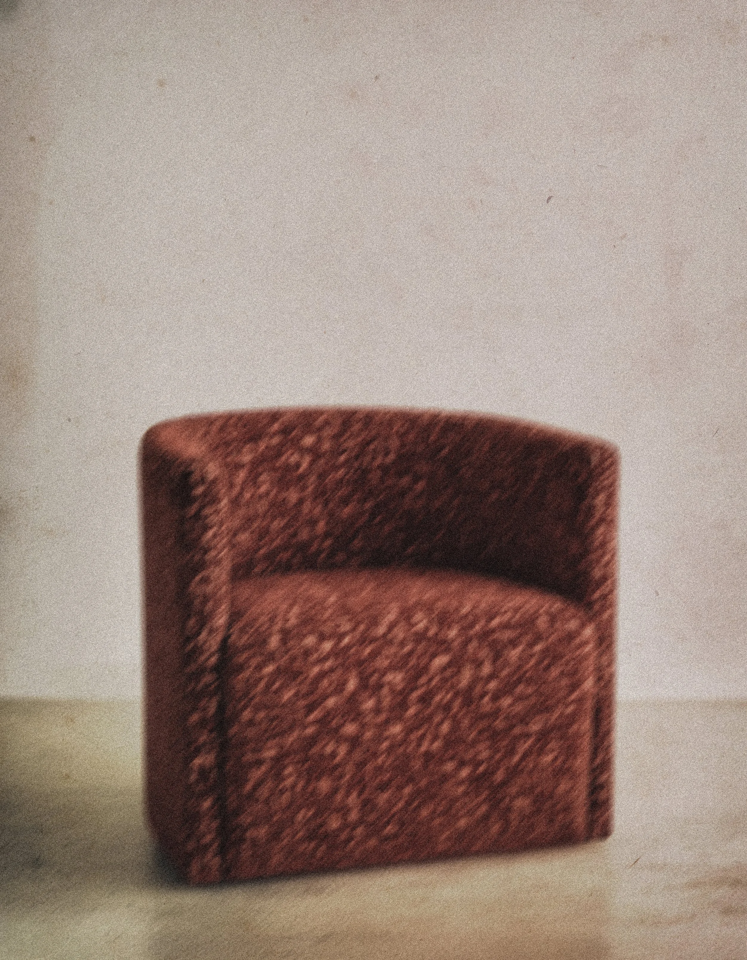 Close-up of a reddish-brown textured object, possibly a book or box, on a white surface.