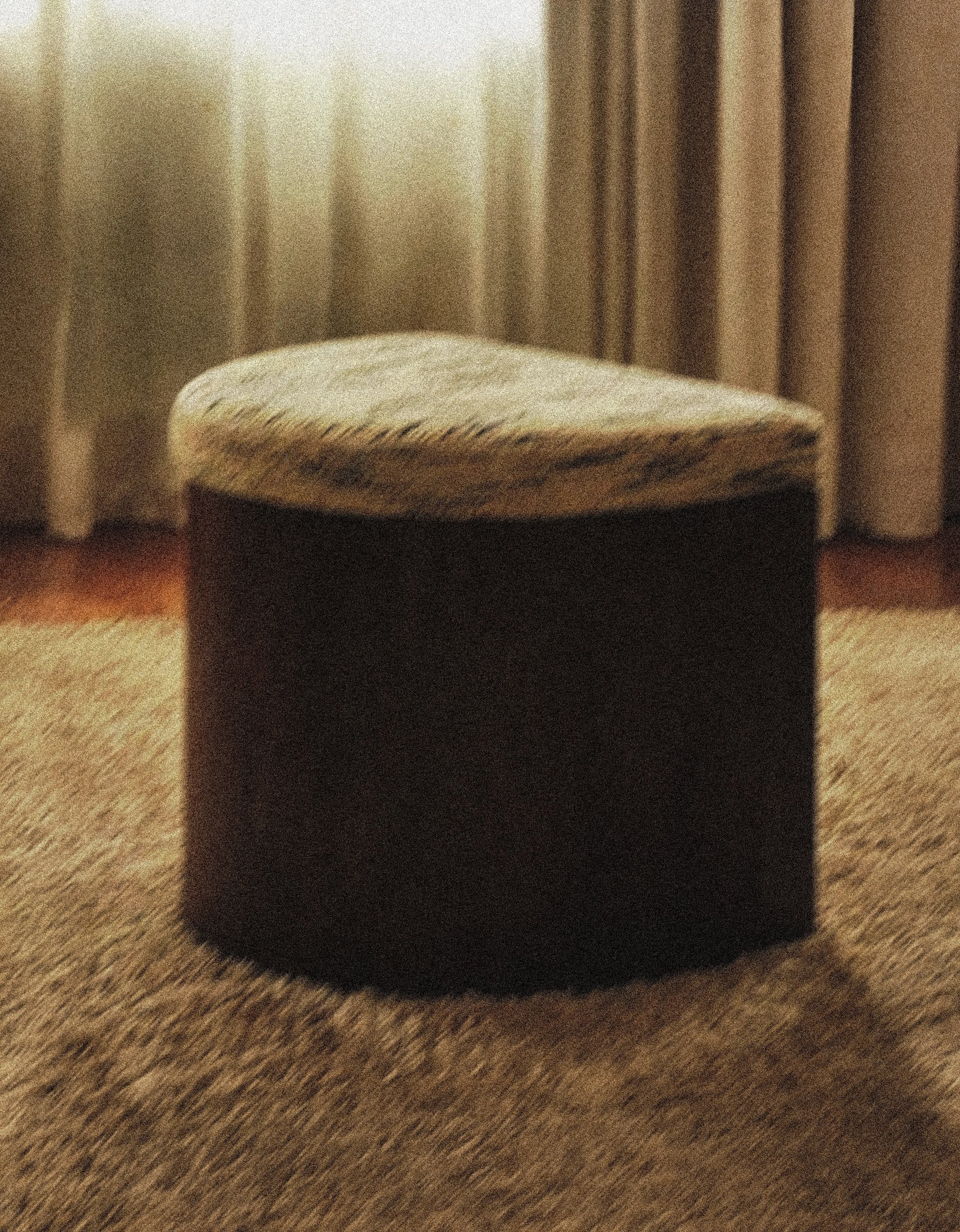 A small black stool with a cushioned beige and gray patterned top, sitting on a wooden floor with beige curtains in the background.