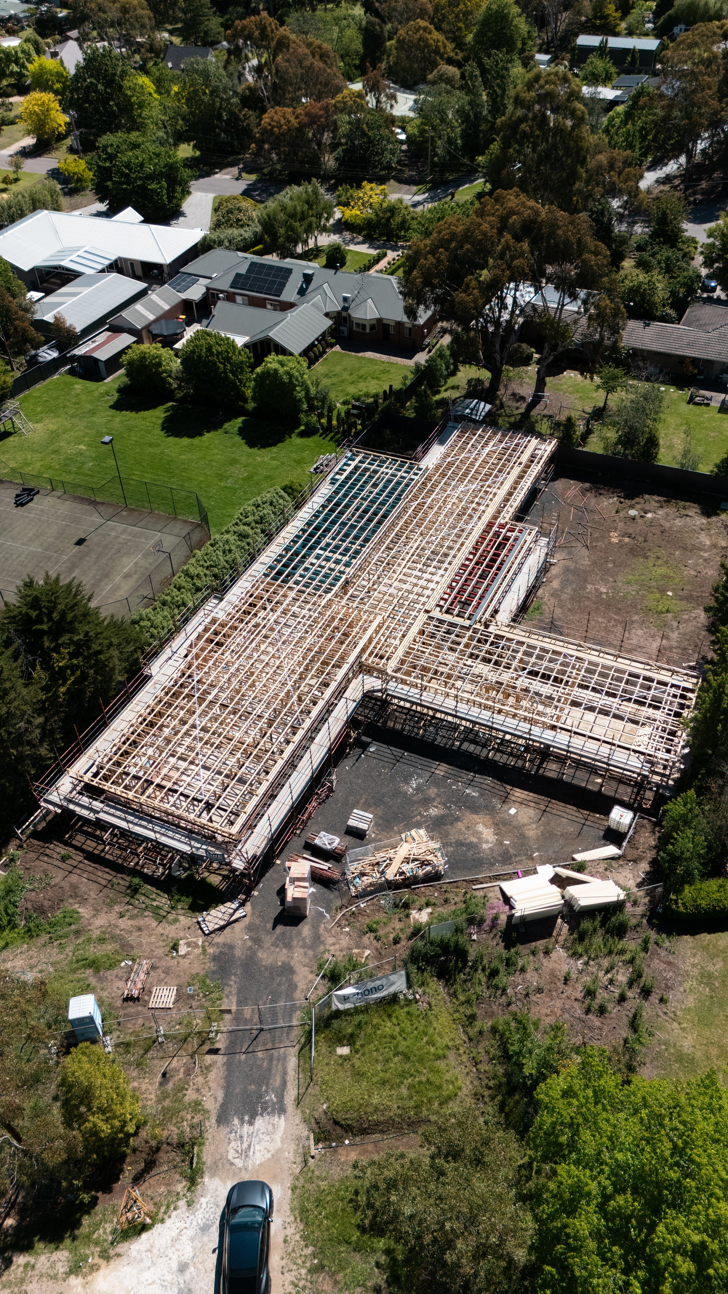Aerial view of a building under construction with wooden framing in a residential neighborhood Melbourne