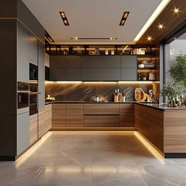 Modern kitchen with dark upper cabinets, wooden lower cabinets, marble backsplash, and under-cabinet lighting. There are built-in appliances, open shelves with dishes, and a large window with a view of plants outside.
