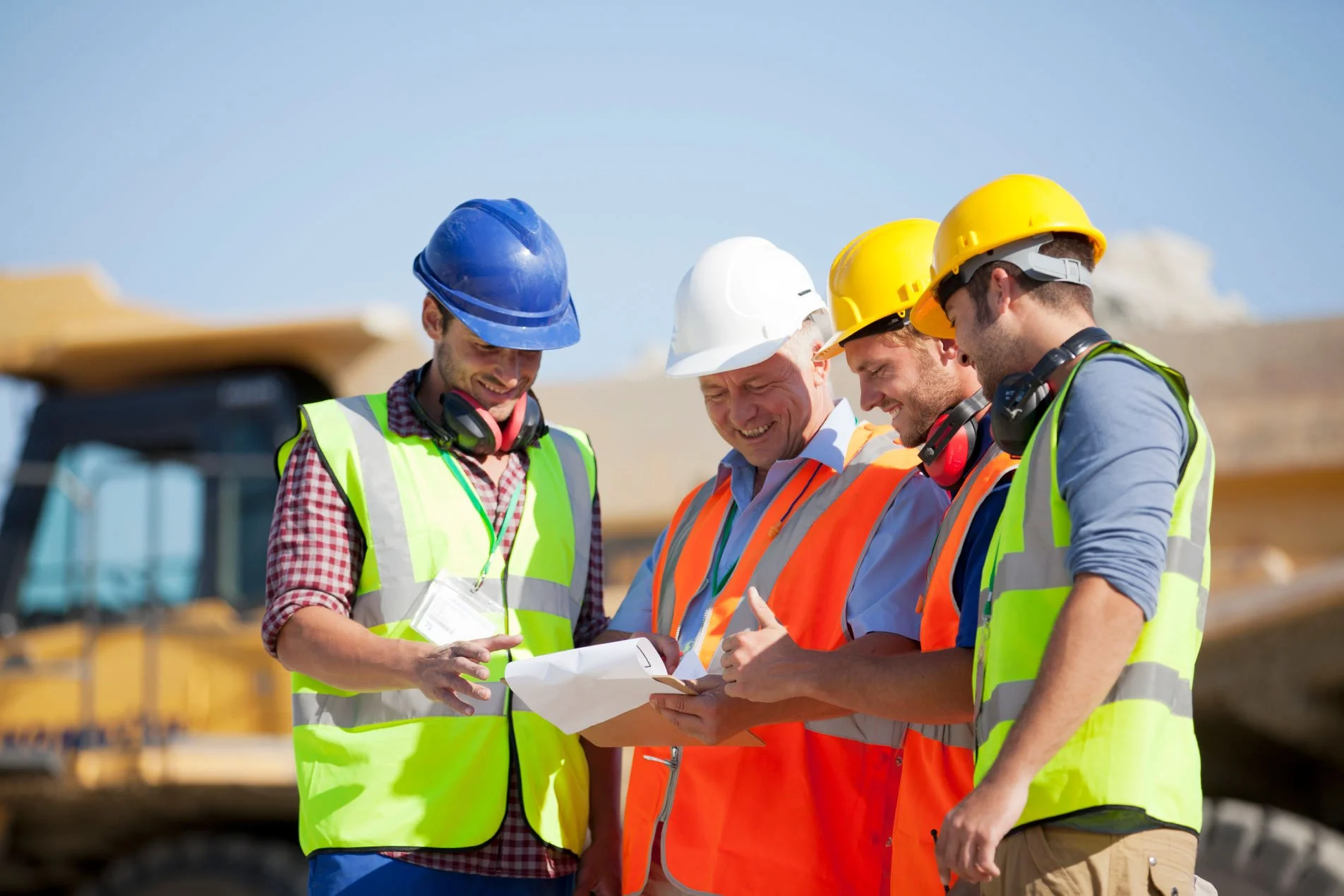 Construction site manager speaking with supervisors on an active construction site.