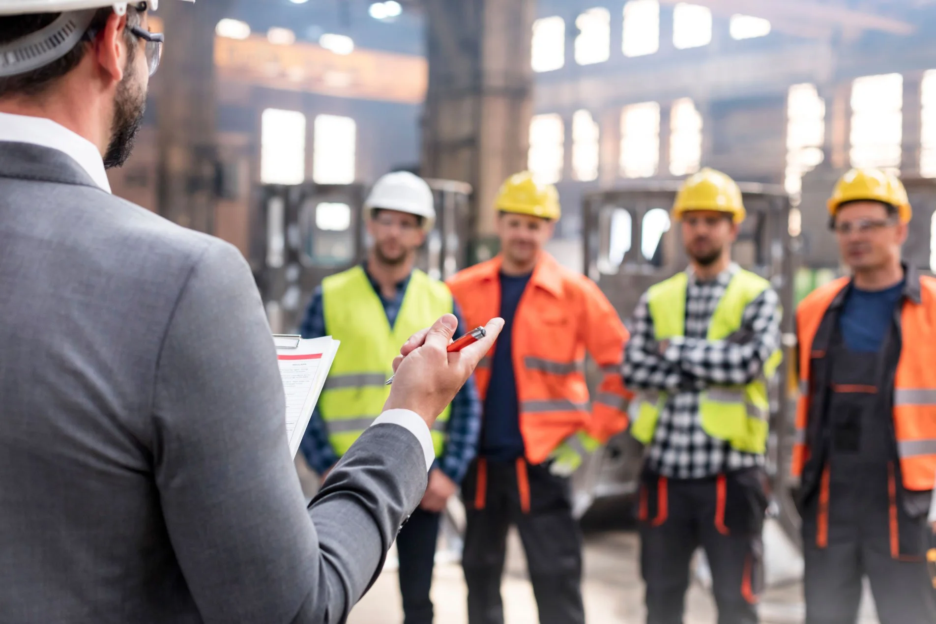 Construction site manager talking with tradespeople on a construction site.