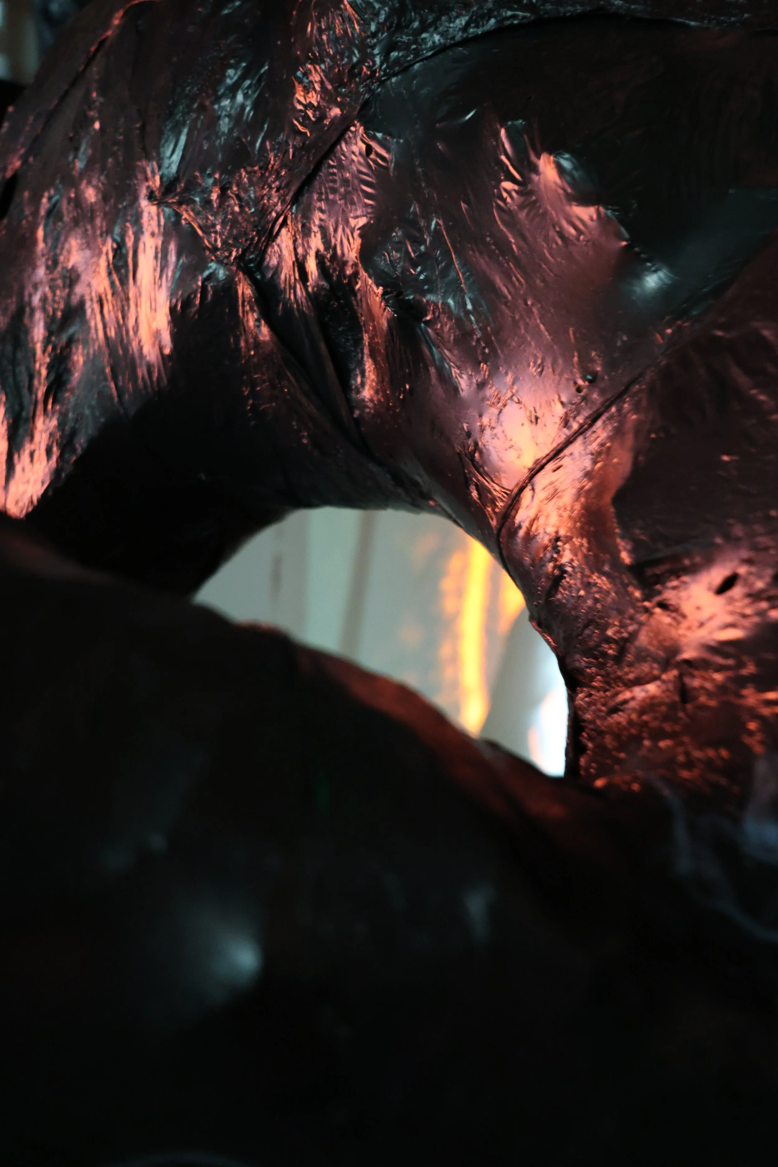 Close-up of a reflective, crumpled metallic surface with hues of pink and blue, possibly showing sunset or sunrise reflections.