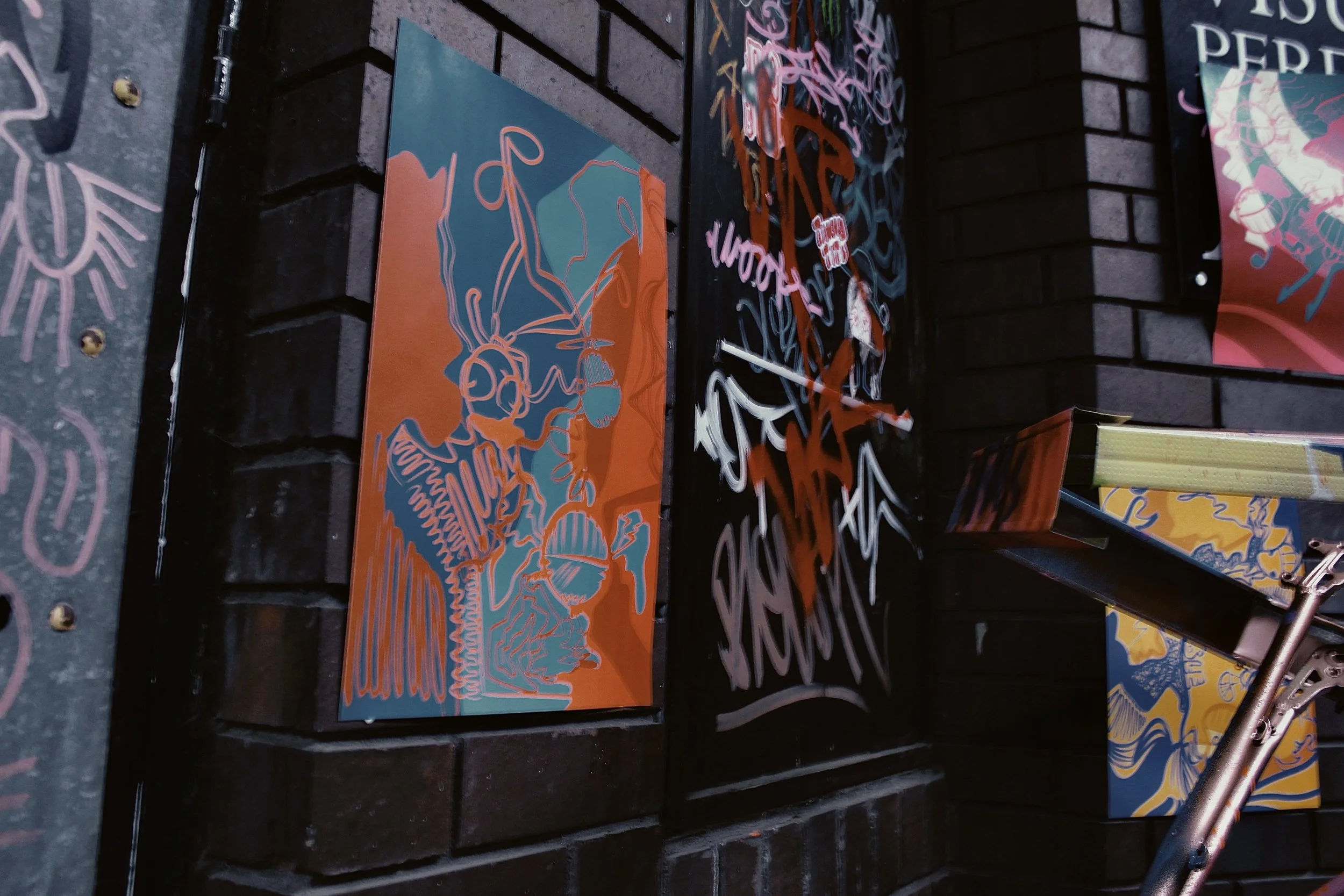 Street art and graffiti on a brick wall, featuring abstract colorful designs and tags.