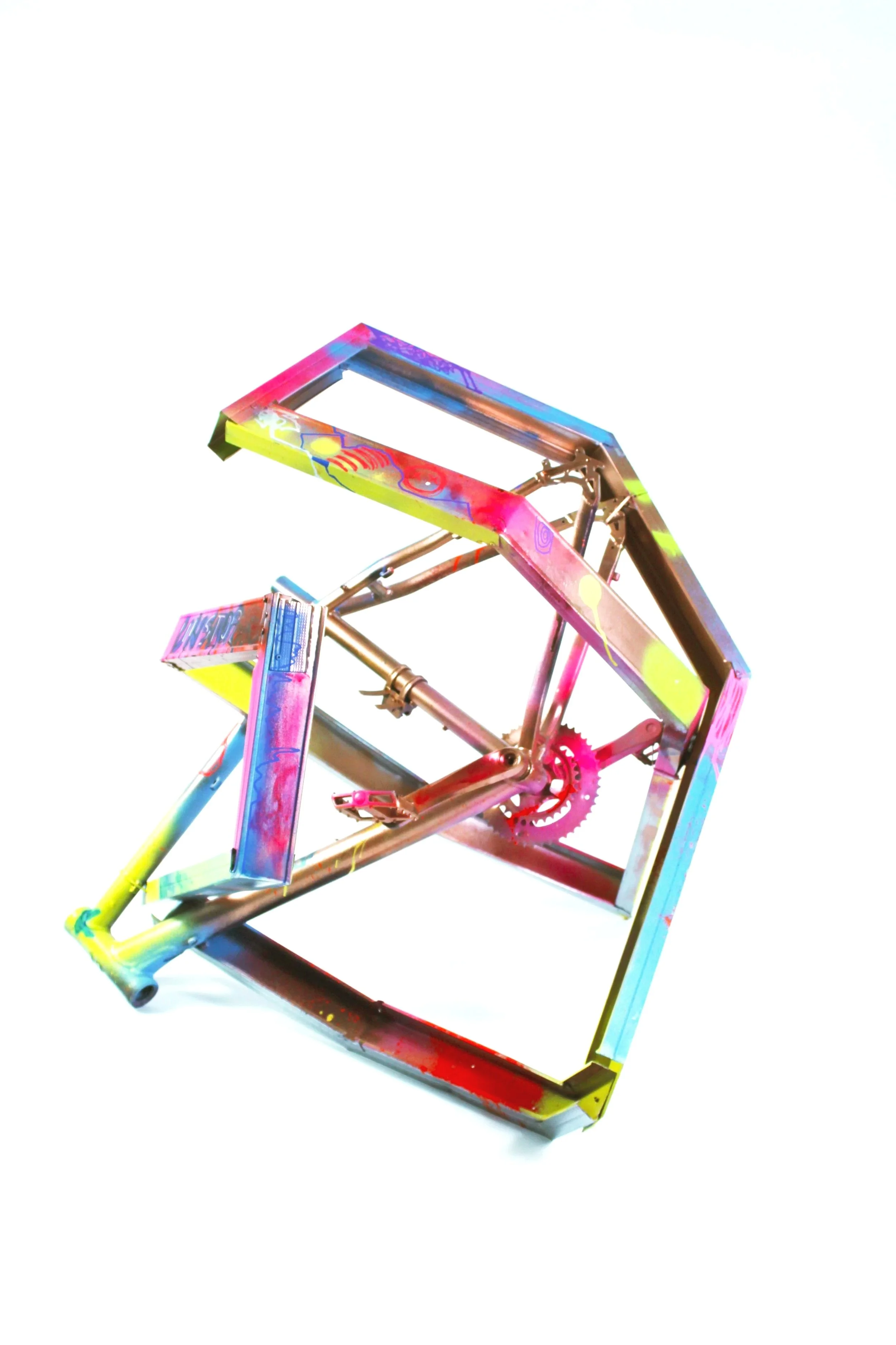 Colorful, abstract sculpture made of metal, with spray paint splatters and geometric shapes, set against a white background.