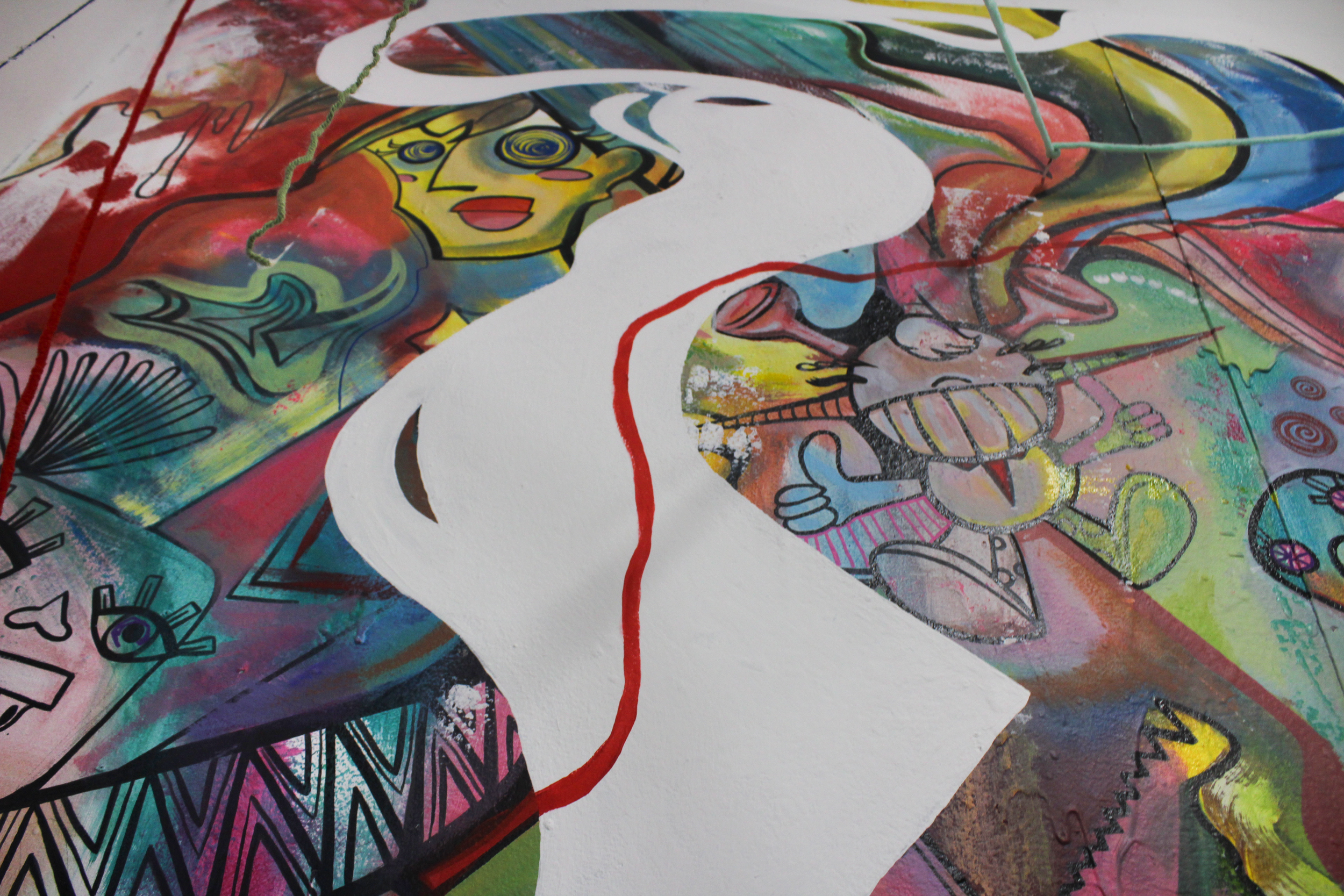 Abstract graffiti art featuring vibrant colors, cartoon faces, and patterns, with a white cutout of a woman's profile in the foreground.