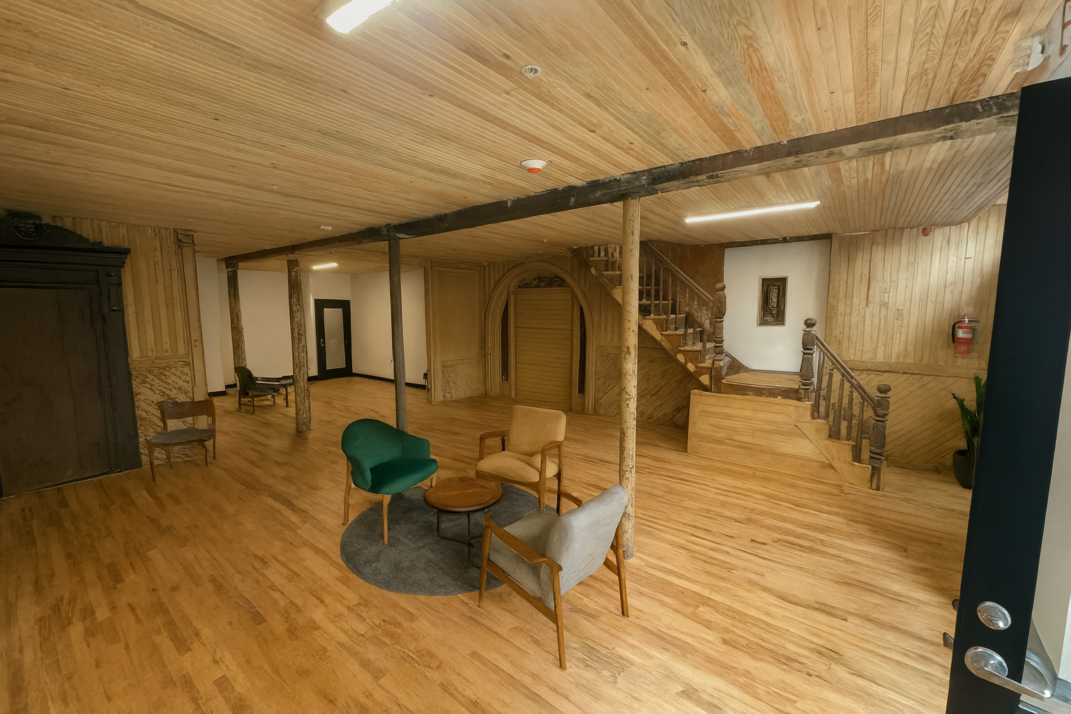 Interior of a wood-paneled room with seating area, staircase, and wooden accents.