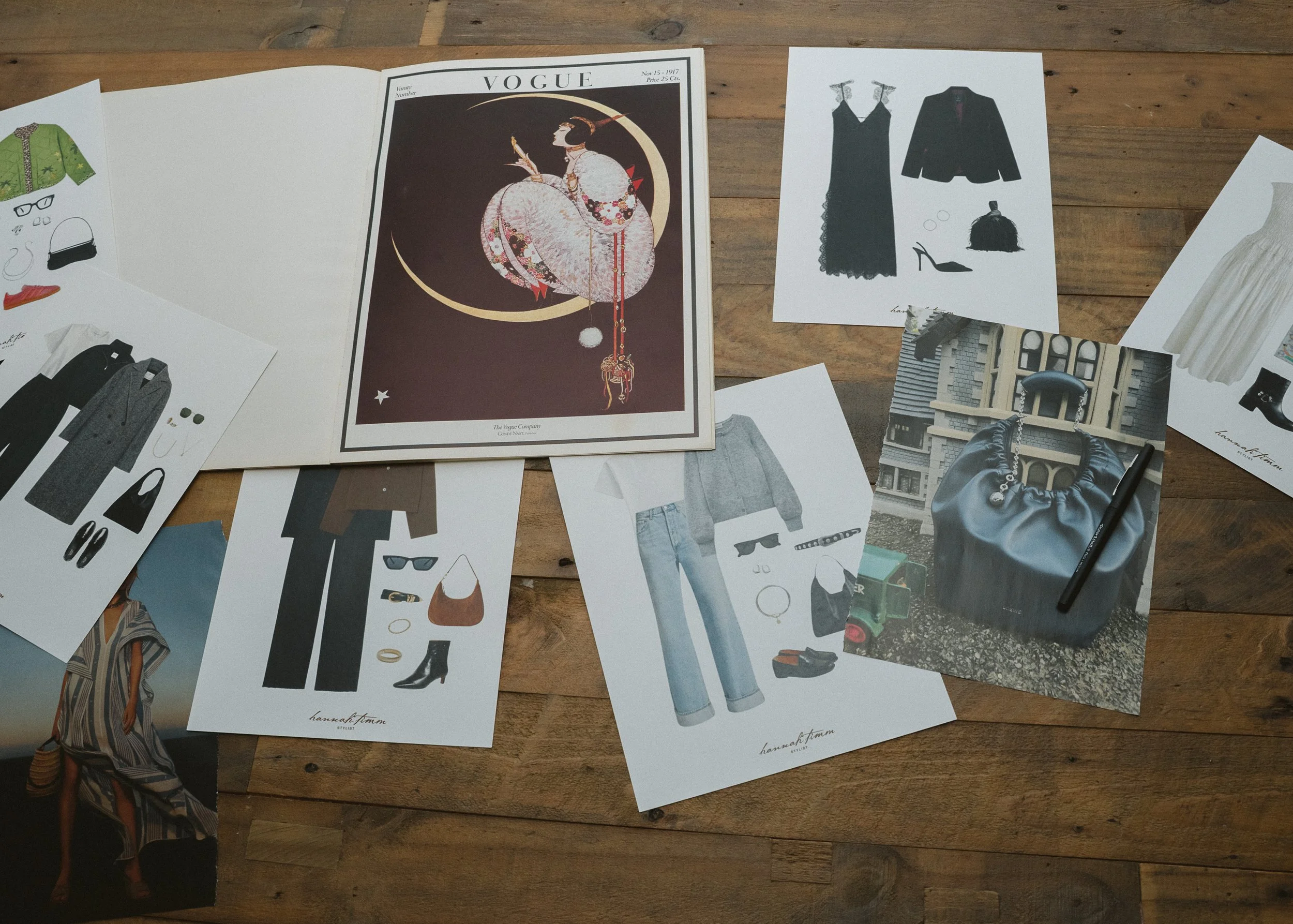 Collage of fashion sketches and magazine covers spread out on a wooden table, including Vogue magazine and various clothing and accessory illustrations.