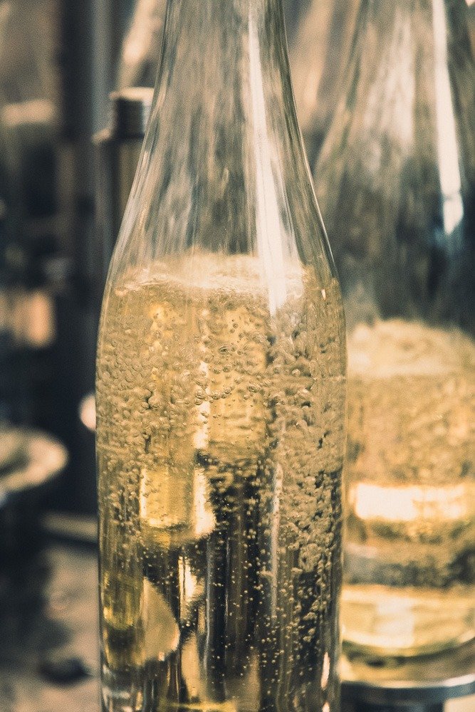 Blick auf eine Flasche mit sprudelndem Wasser oder einer ähnlichen Flüssigkeit.