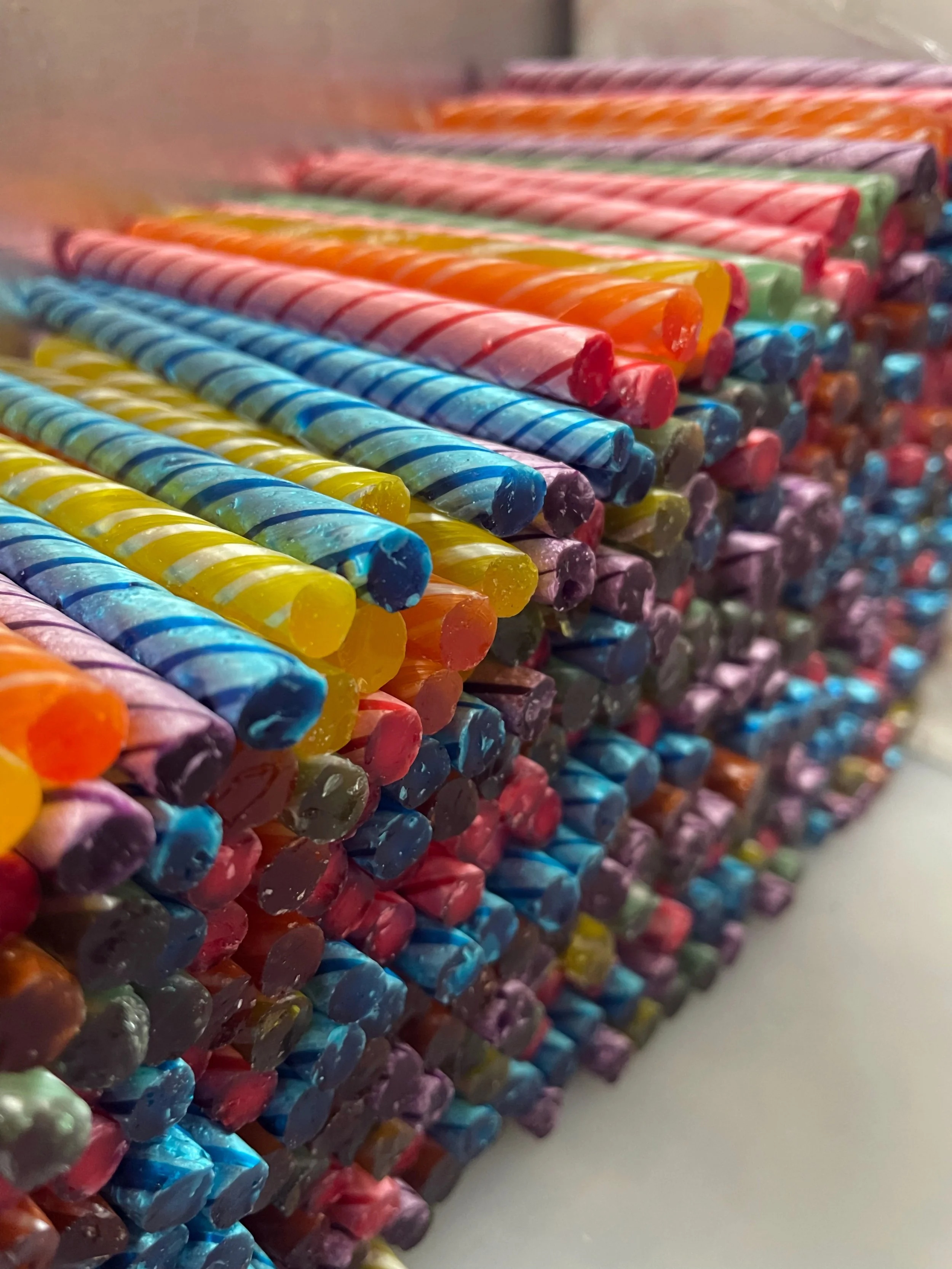 Colorful rolled candles arranged in neat rows.