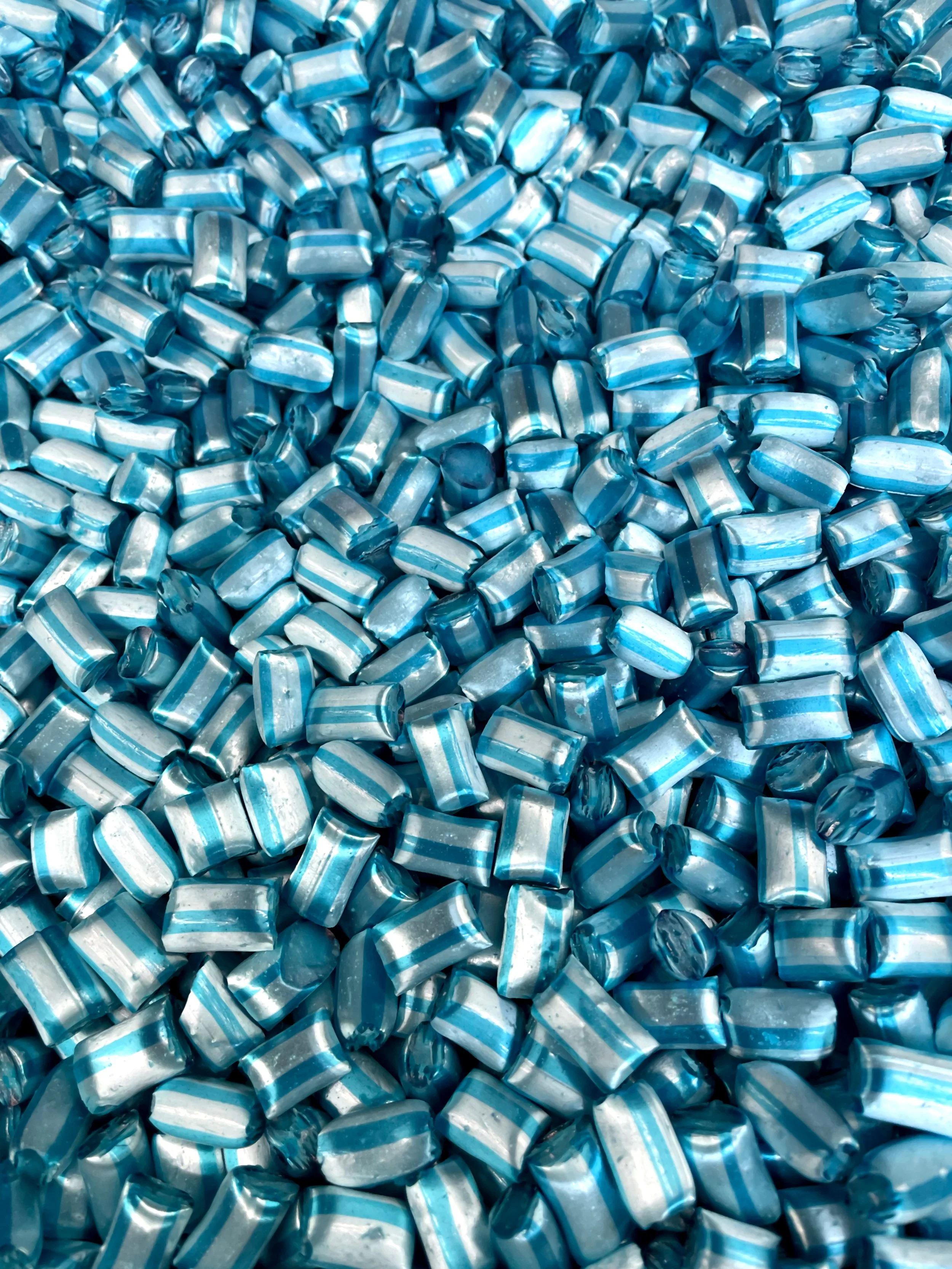 A large pile of small, shiny, blue and white striped candies.