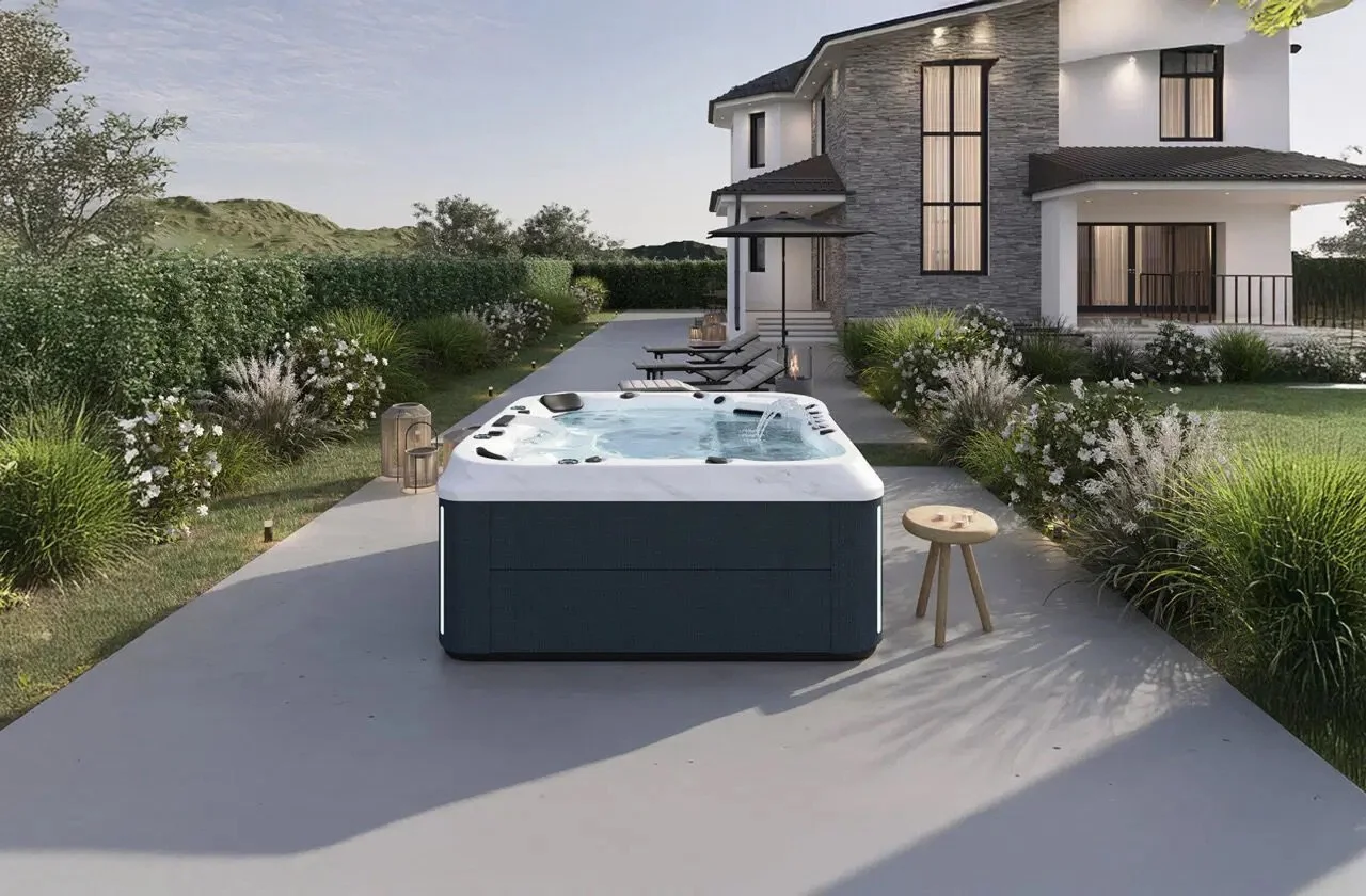 Modern house backyard with hot tub, lounge chairs, and decorative greenery.