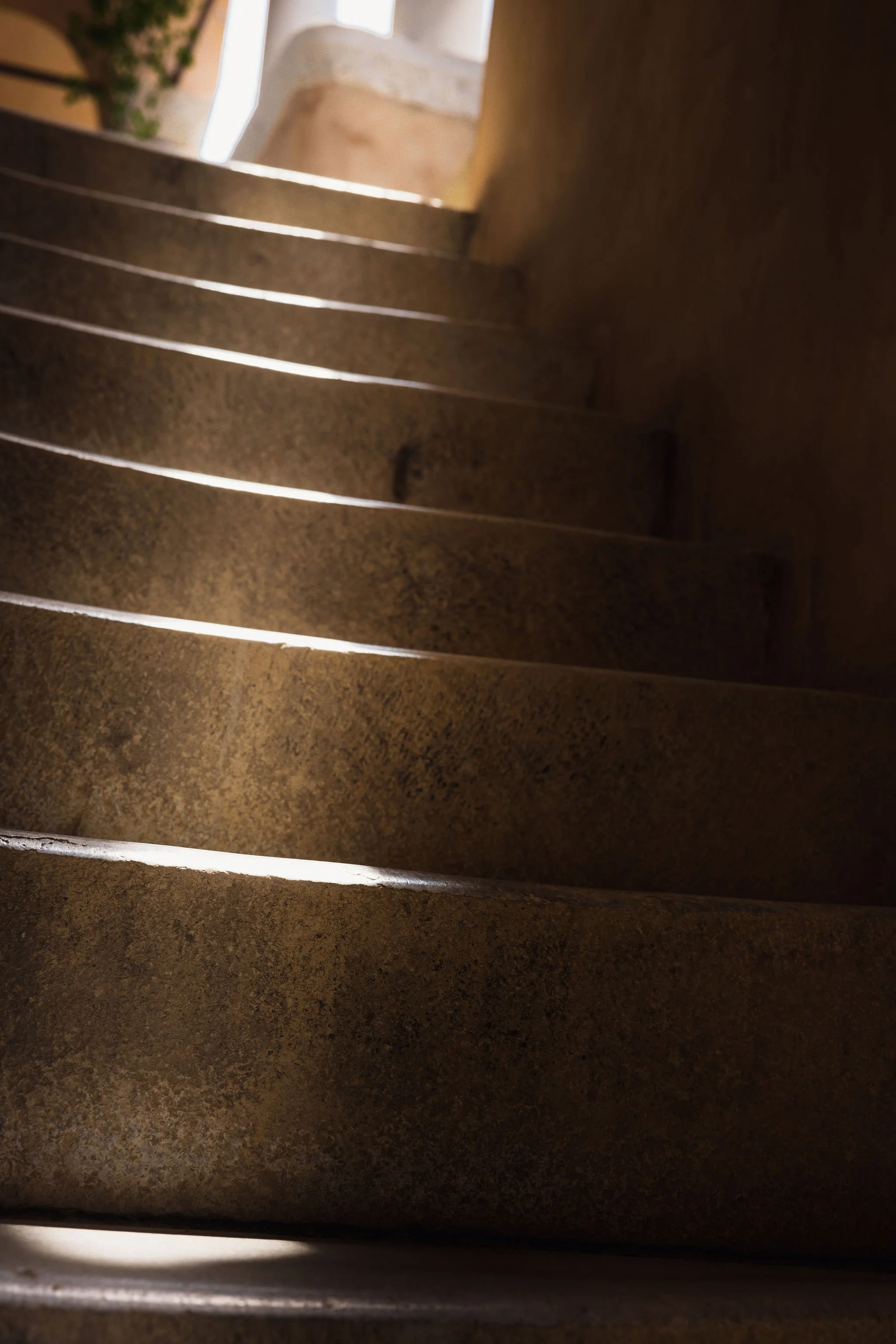 Close-up of stone or concrete stairs with light shining through gaps.