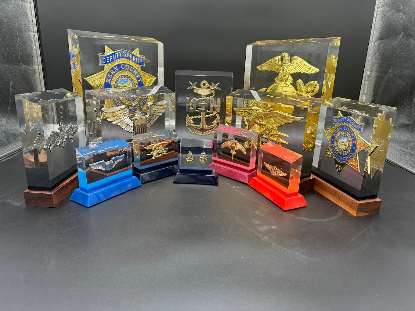 PromilleoGlass BallistiGlass and GhostGlass recognition monuments featuring military insignia and law enforcement badge displays in premium glass