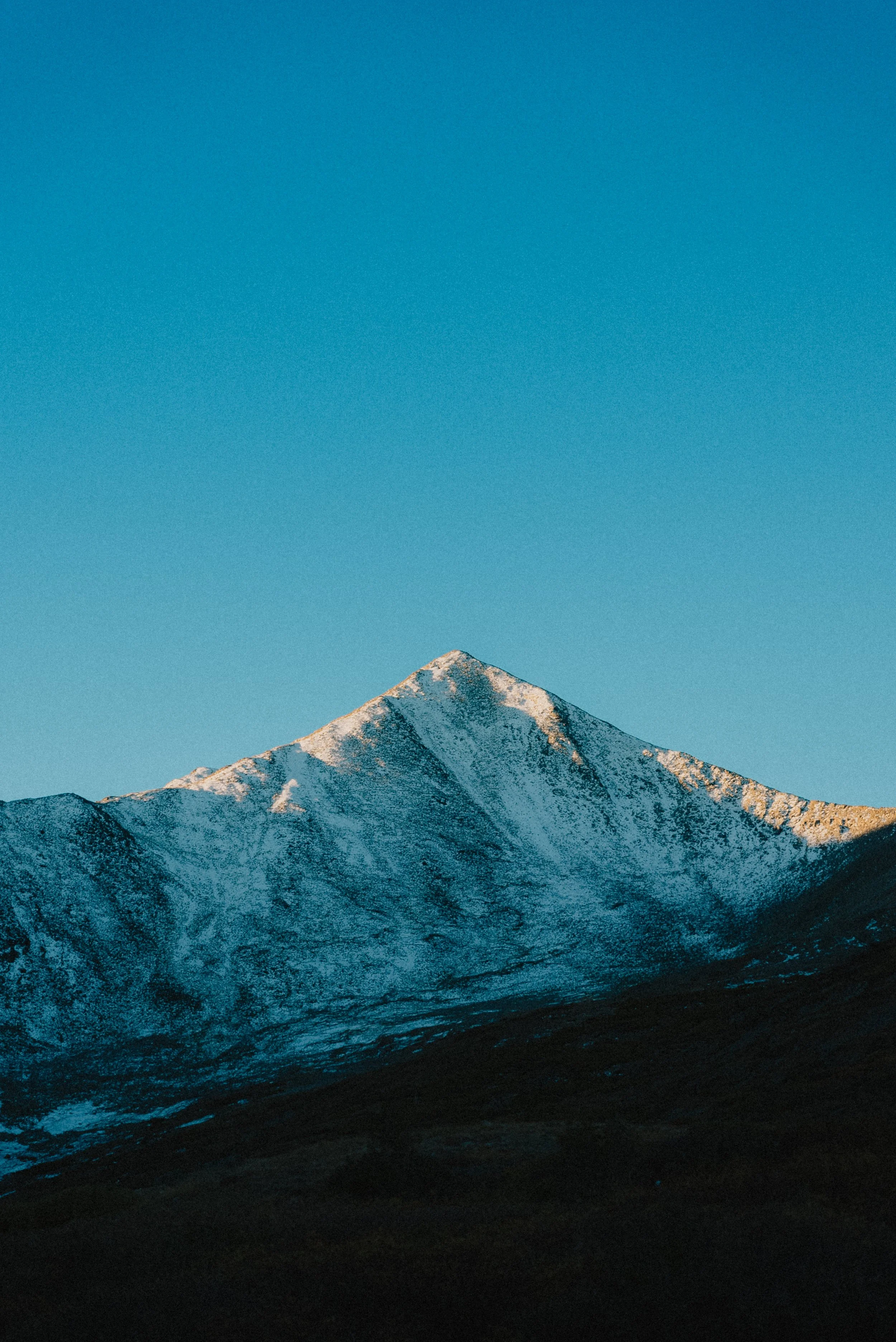 Snow-capped mountain under a clear blue sky.