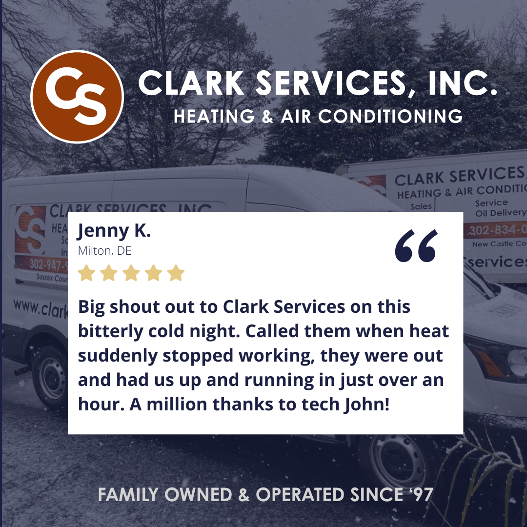 Outdoor view of Clark Services, Inc. vans with the company logo and contact information parked in a snowy area, trees in the background.