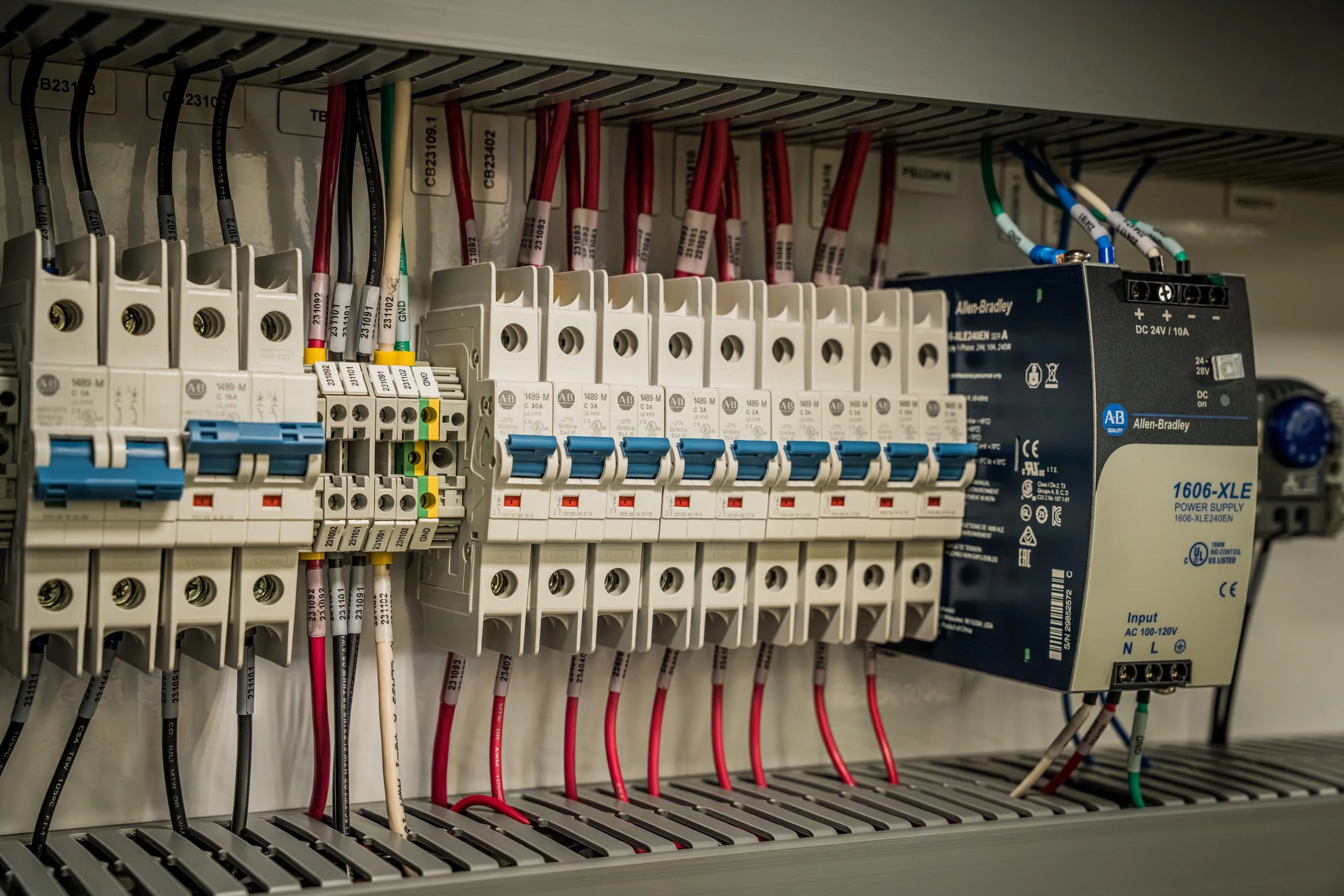 Electrical panel with circuit breakers and a power supply unit.