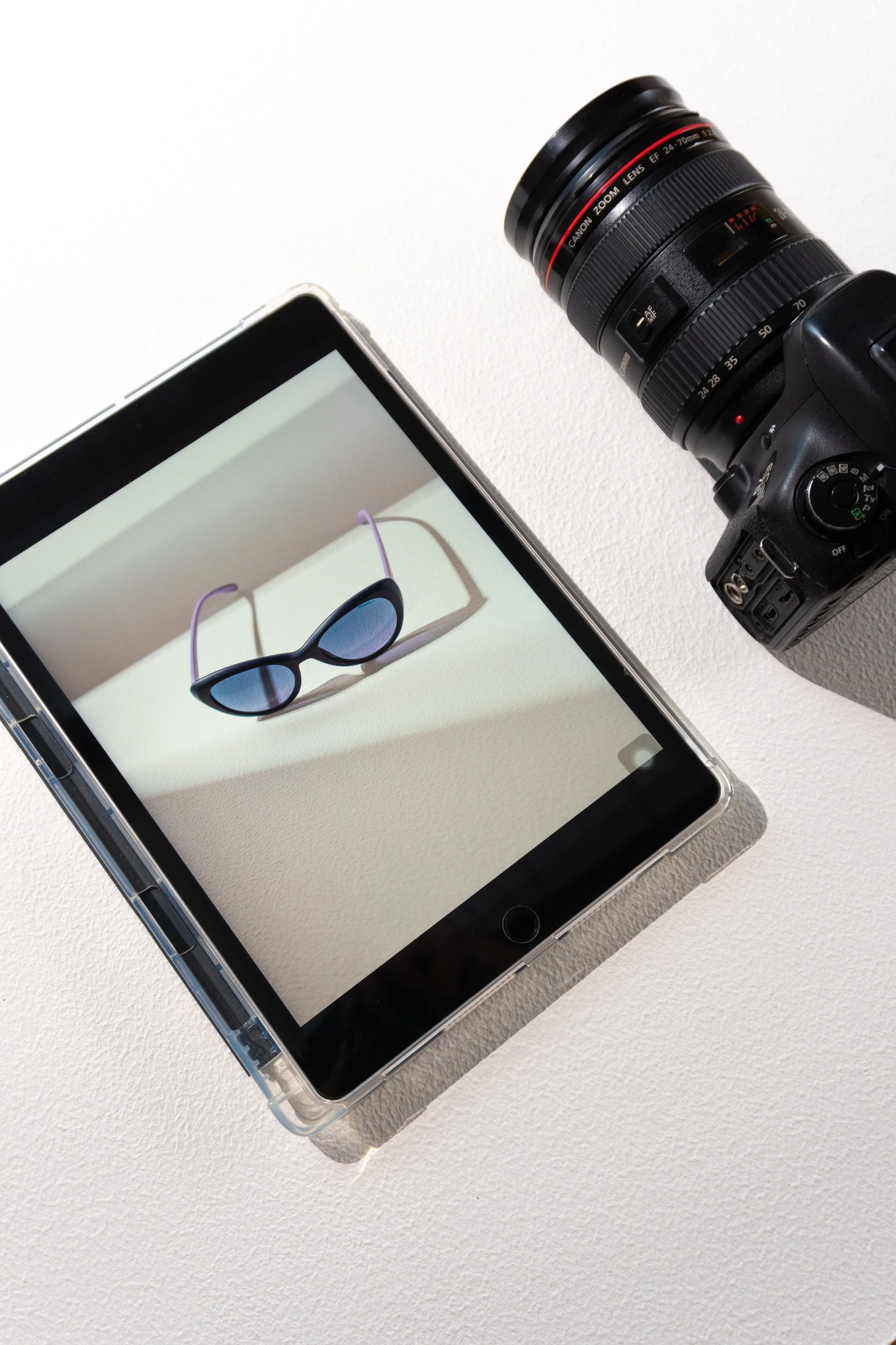 Lentes de sol en una tablet, con una cámara en un costado.