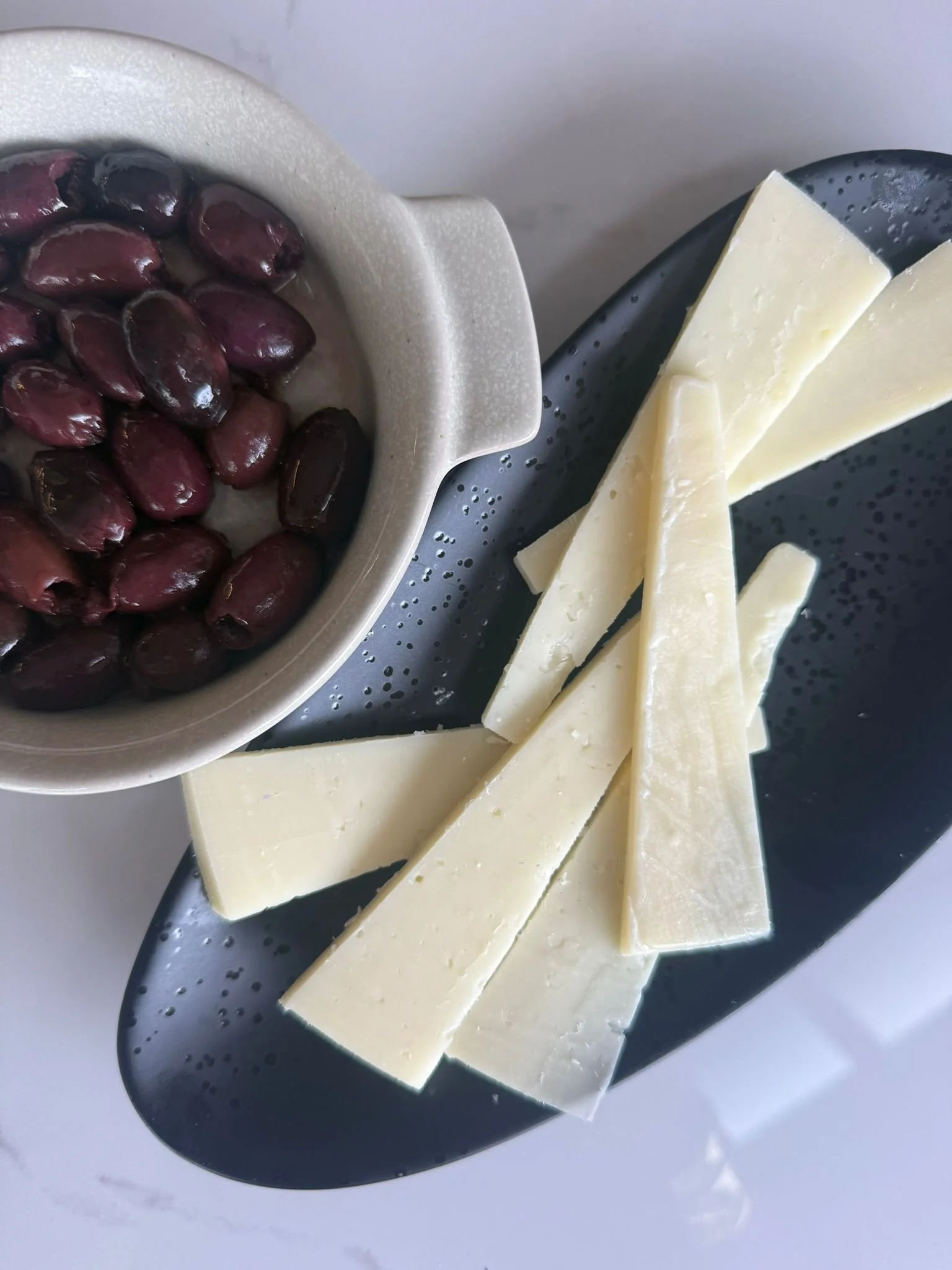 Kalamata olives and greek cheese served on sharing plates.