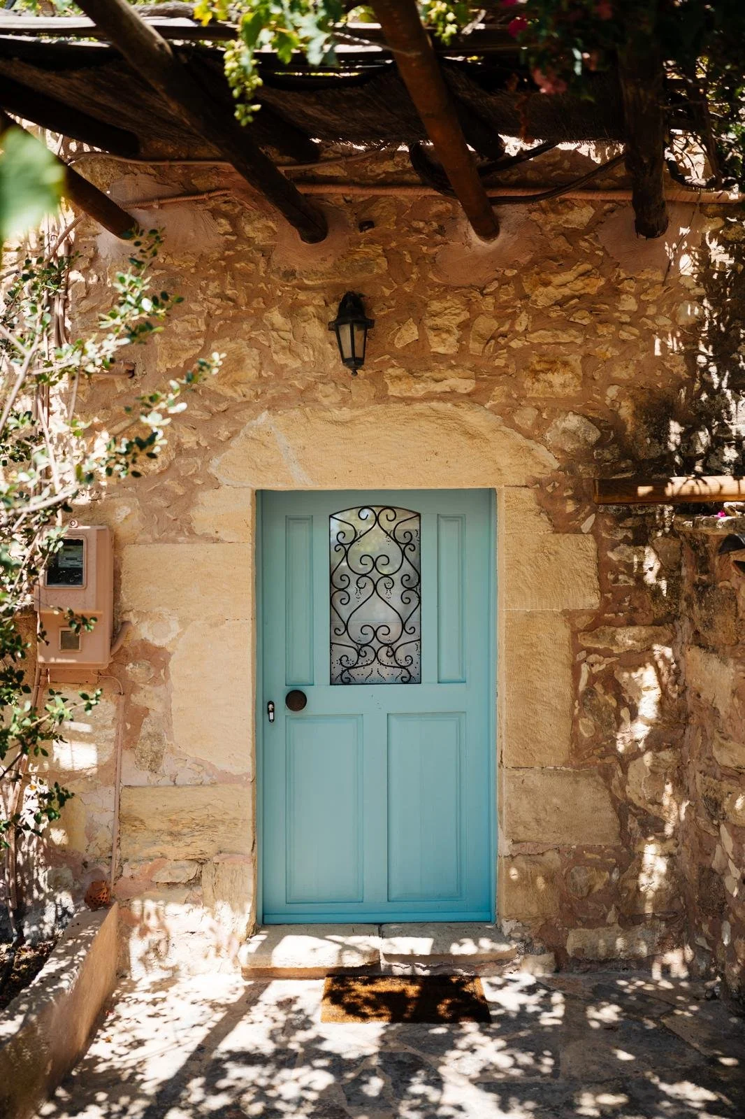Traditional Mediterranean stone building with a pastel blue doorway.