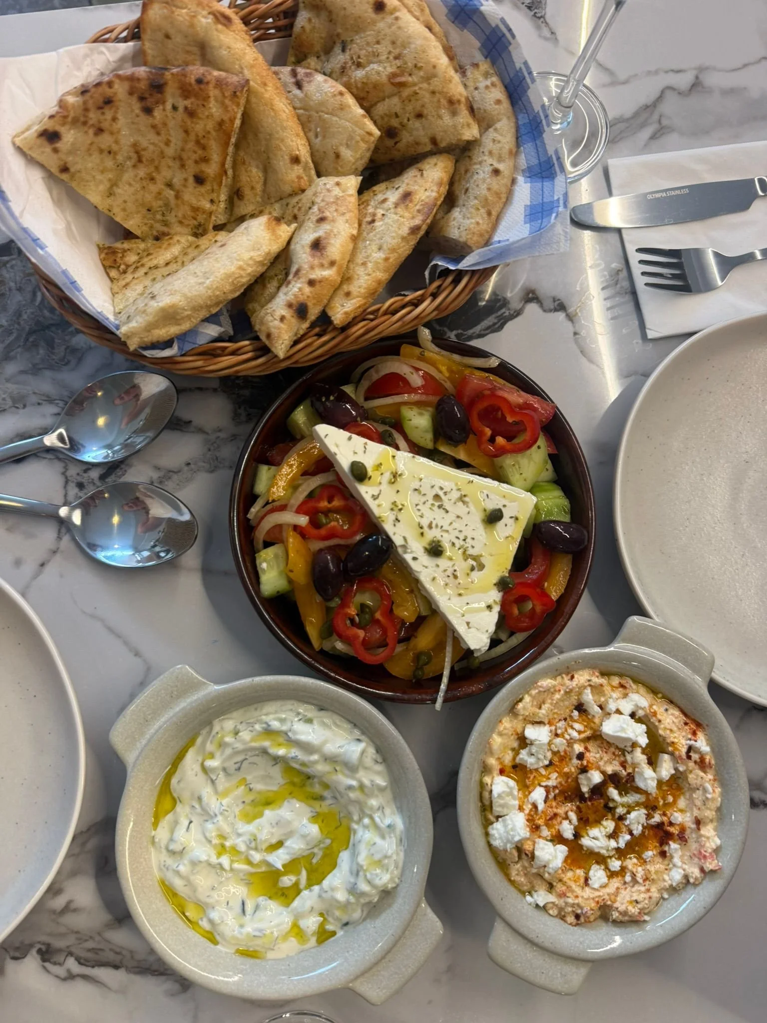 A selection of mediterranean dishes served on a marble table.