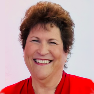 A smiling woman with short brown hair wearing a red top