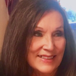 Close-up photo of a woman with long dark hair smiling.