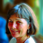A woman with short brown hair smiling outdoors