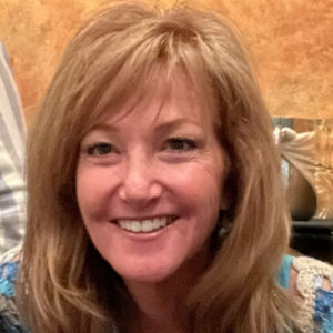 A woman with shoulder-length blonde hair smiling at the camera.