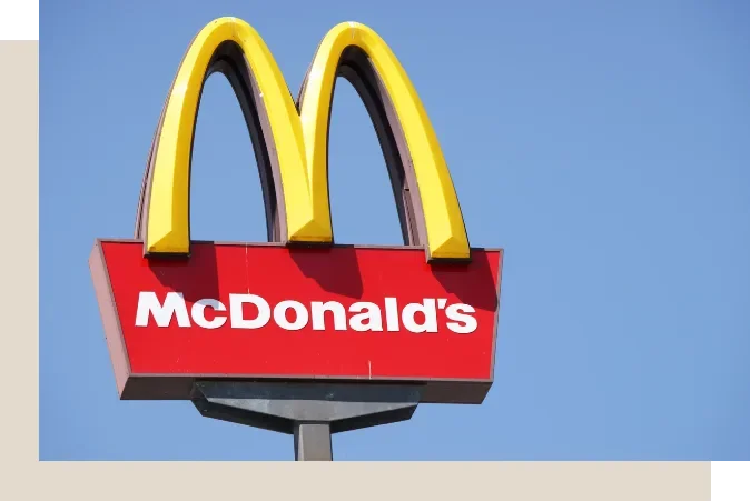 McDonald's sign with yellow arches over a red background with the company name in white.