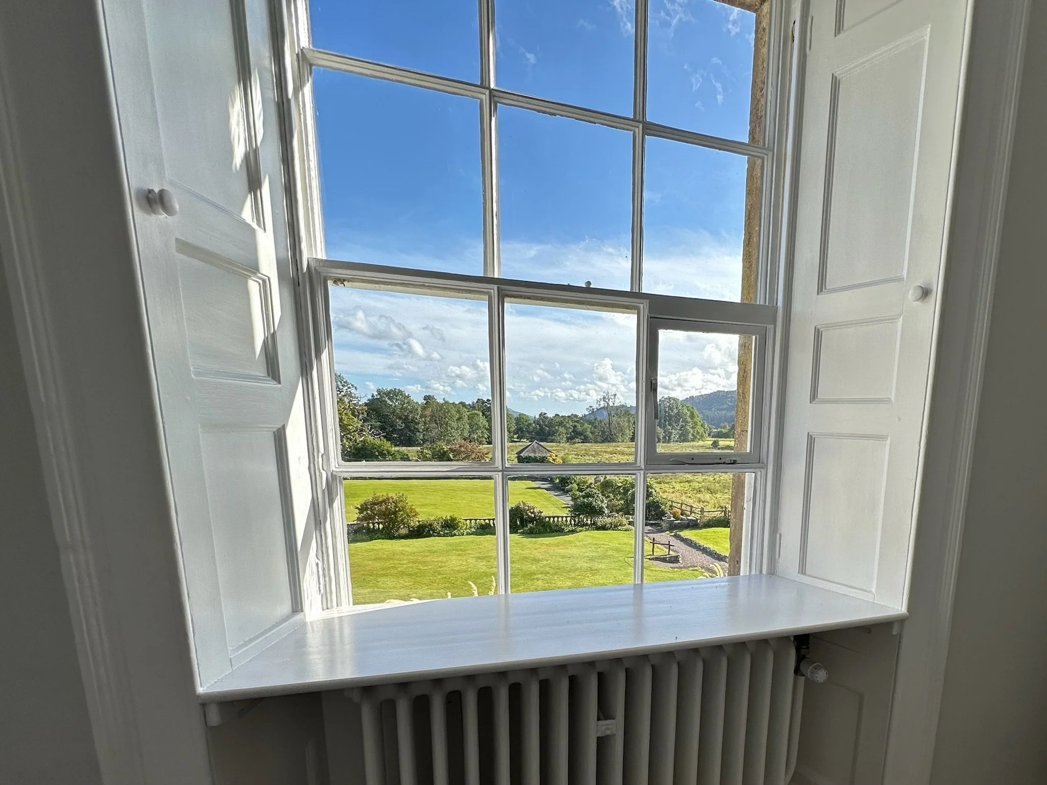 Countryside view through a historic sash window at Calgarth Park.