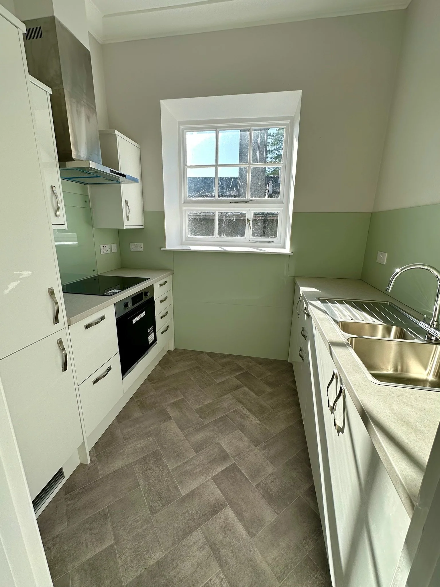 Kitchen area within a Calgarth Park apartment featuring modern units and natural light.