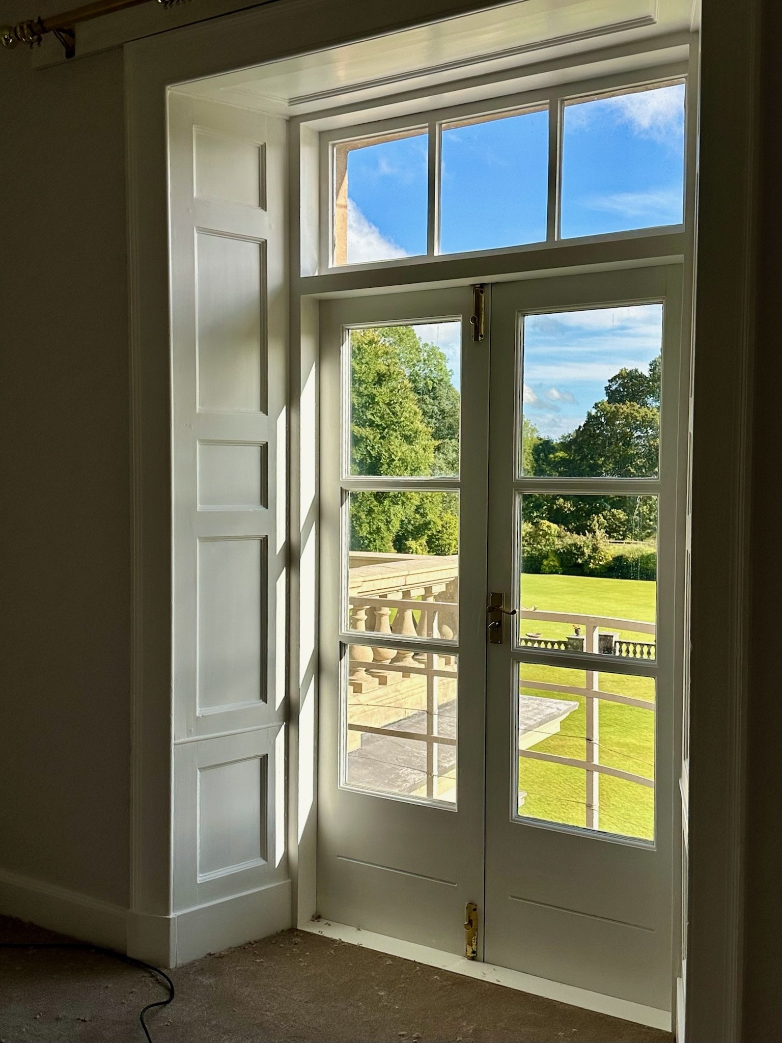 French doors opening from an apartment onto views of the gardens and surrounding landscape.