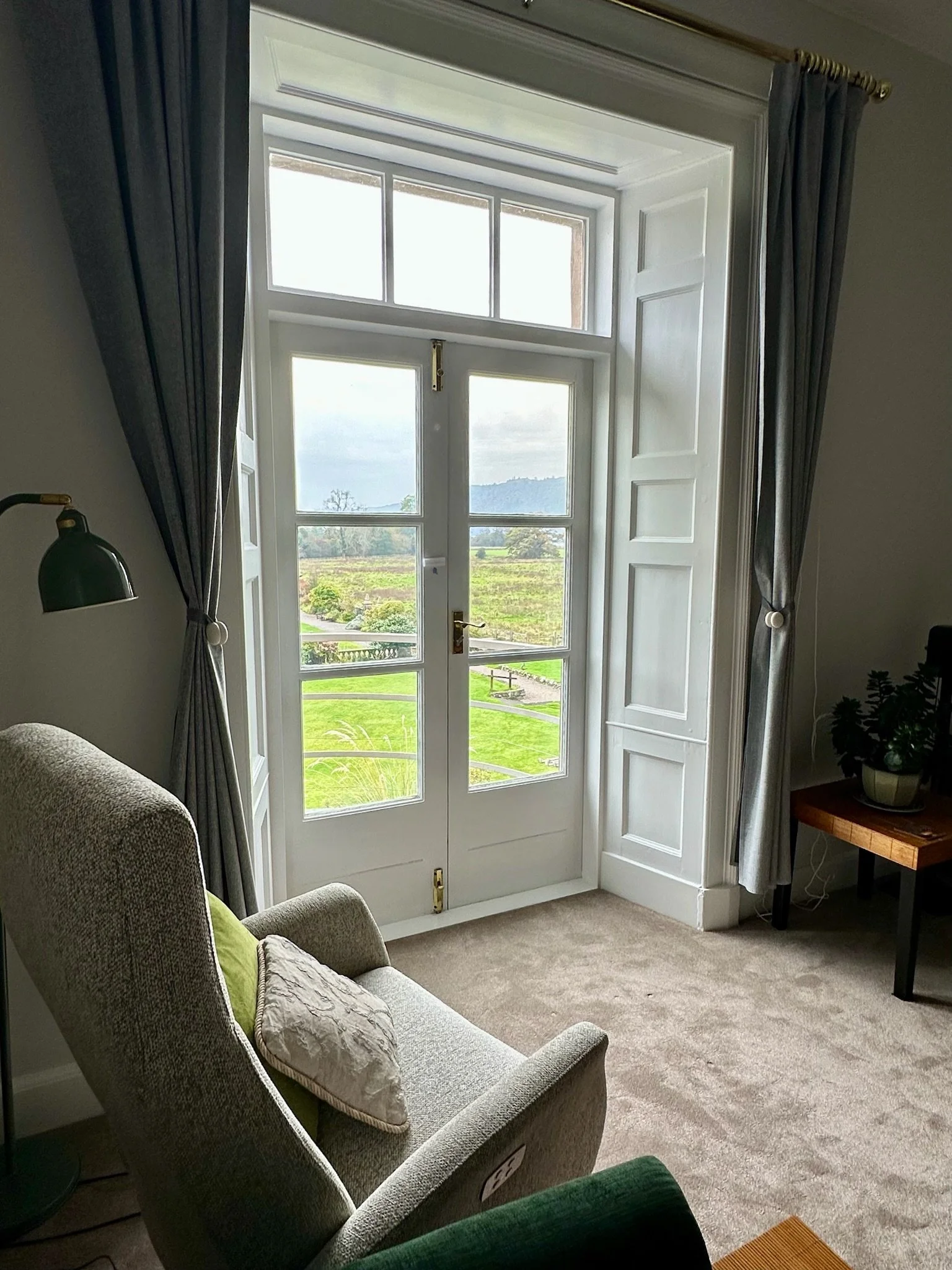 Bright apartment room with large sash window overlooking the gardens and countryside.
