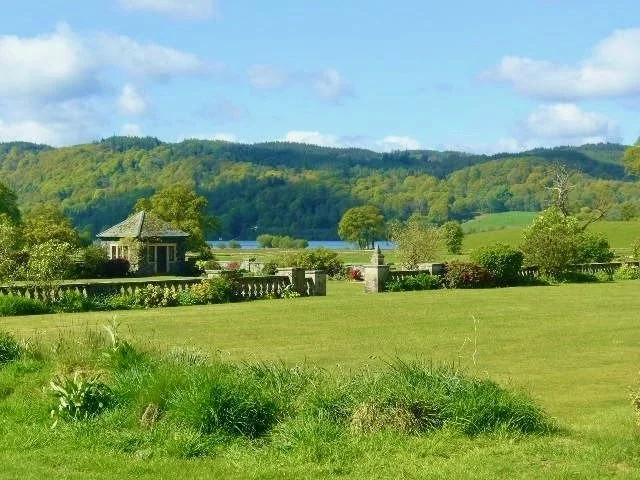 Expansive lawns and gardens at Calgarth Park with views towards Lake Windermere and the surrounding Lake District fells.