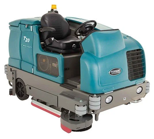 A Tennant T20 ride-on floor scrubber machine with a black seat, steering wheel, and a yellow warning light on top.
