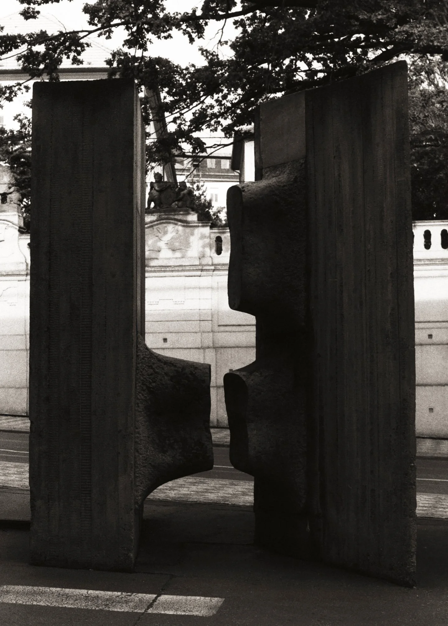 Une sculpture abstraite en bois avec des morceaux assemblés, vue à travers une ouverture dans la sculpture.