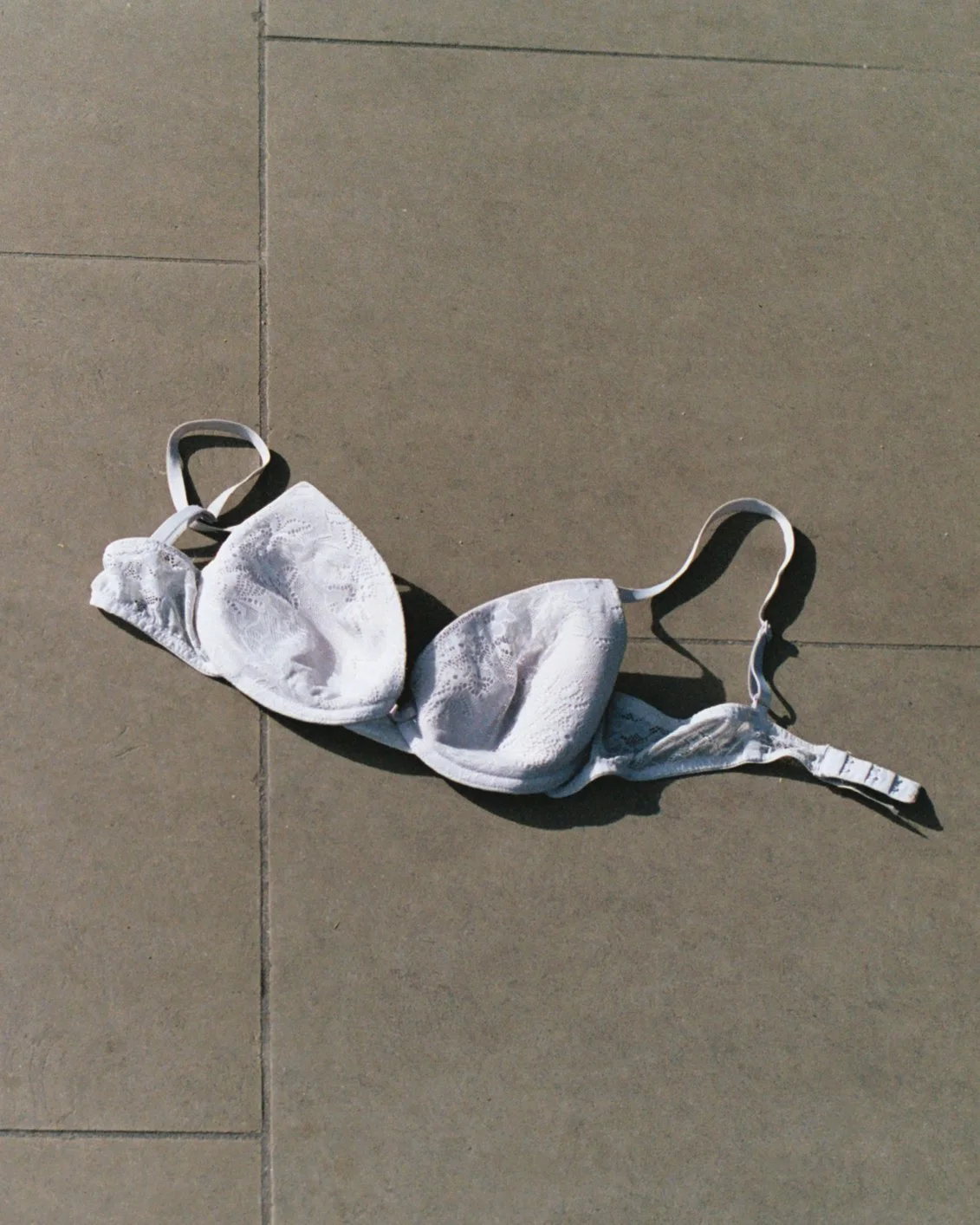 Un soutien-gorge blanc déployé sur un sol en tuiles