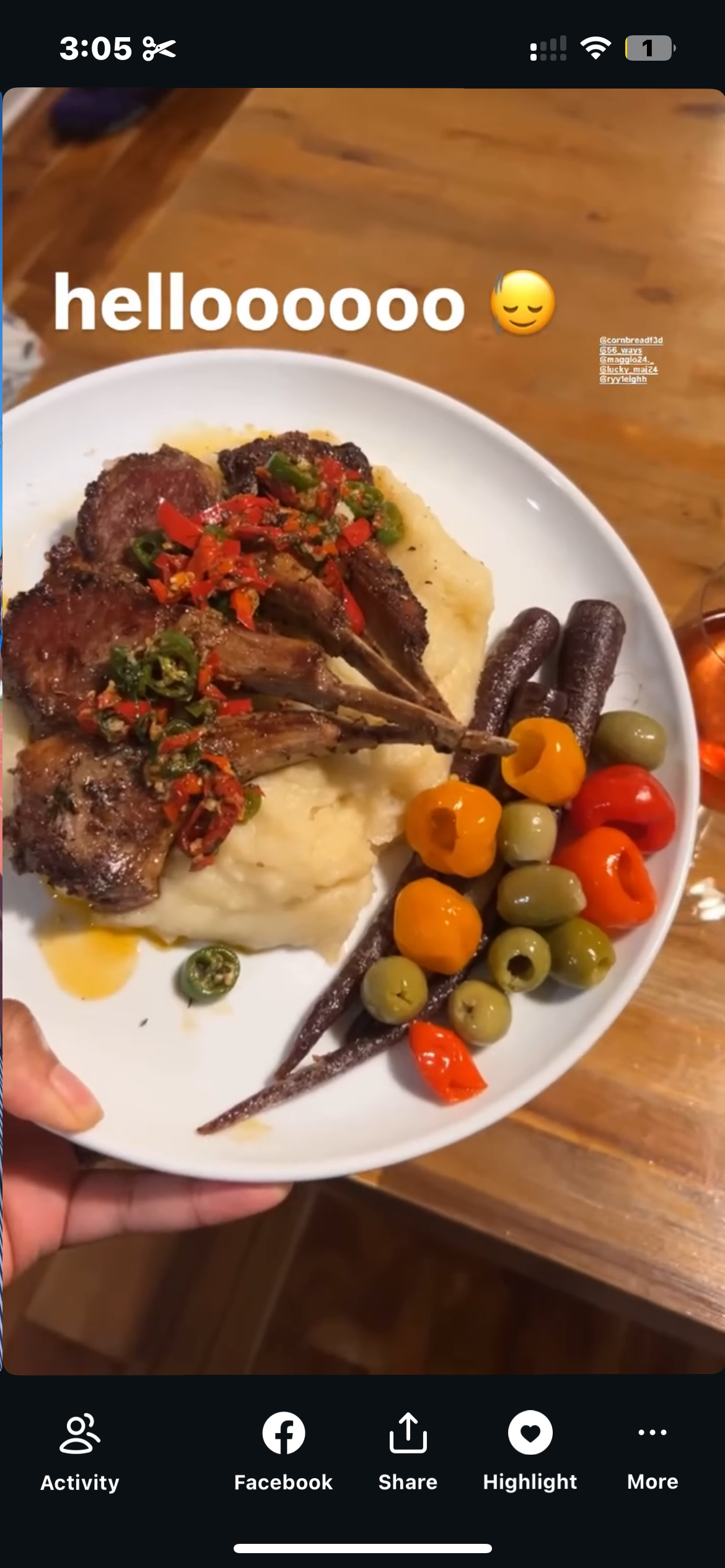 Plate of food with mashed potatoes topped with cooked lamb chops, garnished with chopped peppers, served with mixed olives and roasted vegetables.