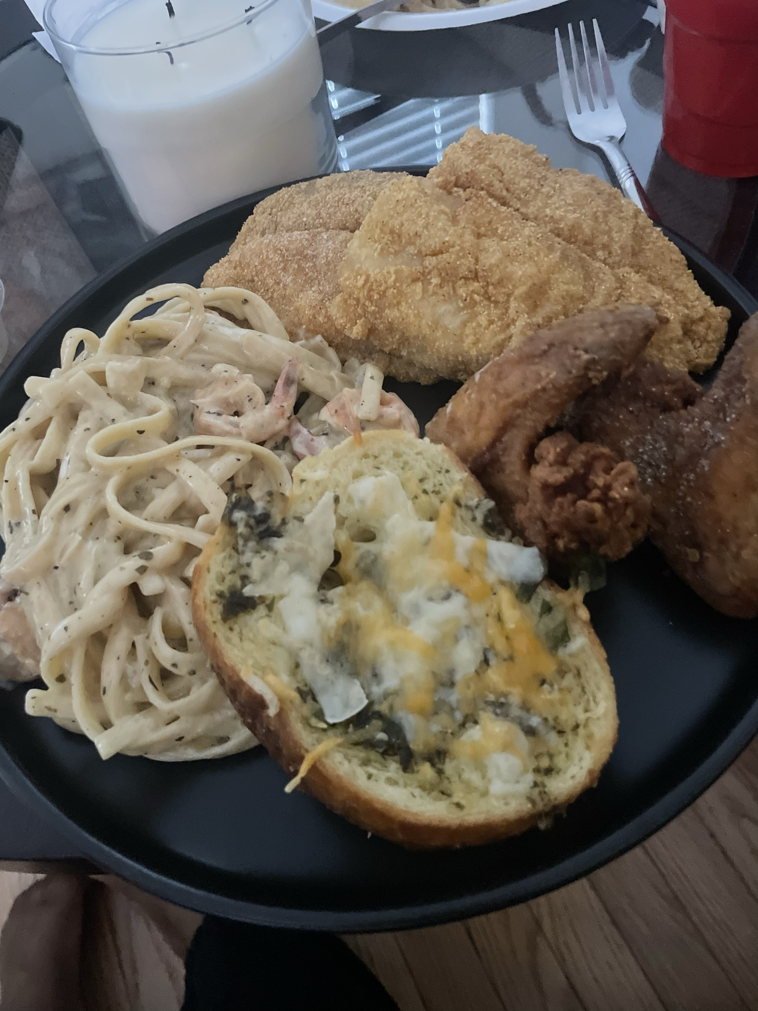 plate of fried chicken, pasta salad, garlic bread with cheese, and a glass of milk.